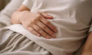 Dłoń na brzuchu, symbolizująca troskę o zdrowie i diagnostykę, np. test ureazowy.