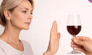 Kobieta odrzuca kieliszek czerwonego wina, sugerując, że po rezonansie można pić alkohol, ale ona woli odmówić.