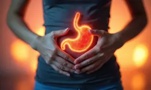 Dłonie obejmujące brzuch, gdzie widoczny jest świecący, czerwony żołądek, symbolizujący gastropatię rumieniową.