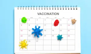 Kolorowe modele wirusów na kalendarzu z napisem VACCINATION.