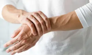 Dłoń uciskająca nadgarstek, widoczne żyły i ścięgna.