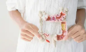 Model jelit z widocznymi zmianami, trzymany przez dłonie.