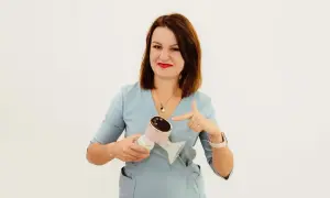 Kobieta w niebieskim fartuchu wskazuje na różowy laktator. To idealne rozwiązanie dla mam, które cenią sobie wygodę i nowoczesność, jak w przypadku Milanella Complex.