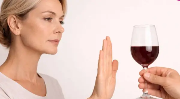 Kobieta odrzuca kieliszek czerwonego wina, sugerując, że po rezonansie można pić alkohol, ale ona woli odmówić.