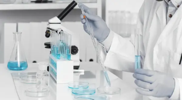 Badacz w laboratorium pobiera próbkę płynu pipetą. Badania nad zespołem Klinefeltera mogą pomóc w lepszym zrozumieniu jego przyczyn i leczenia.