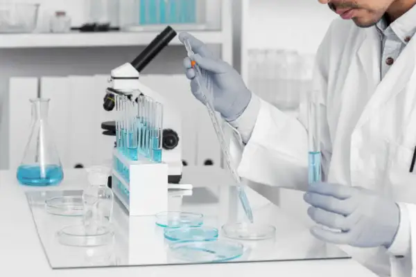 Badacz w laboratorium pobiera próbkę płynu pipetą. Badania nad zespołem Klinefeltera mogą pomóc w lepszym zrozumieniu jego przyczyn i leczenia.