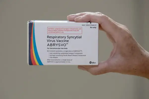 Dłoń trzyma pudełko szczepionki ABRYSVO™ na wirusa RSV.
